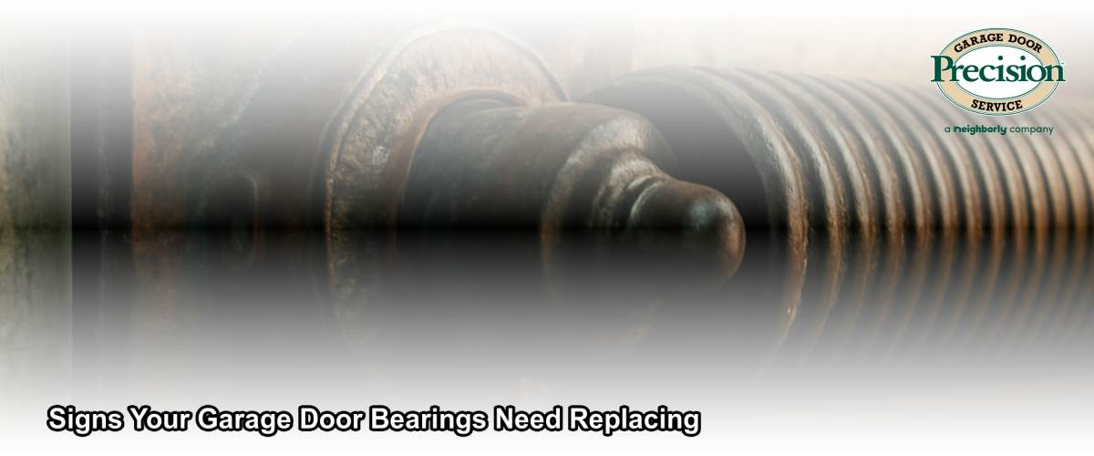 Close-up of a worn garage door torsion spring shaft bearing plate showing rust and wear, inside a Chicago residential garage